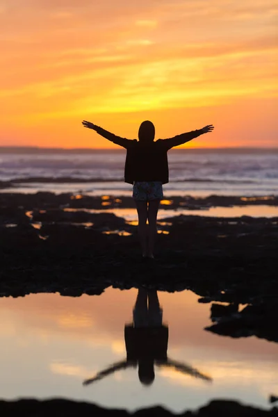 Silueta de mujer libre disfrutando de la libertad sintiéndose feliz en la  playa al atardecer. Mujer relajante serena en pura felicidad y disfrute  eufórico con los brazos levantados extendidos . — Naturaleza,