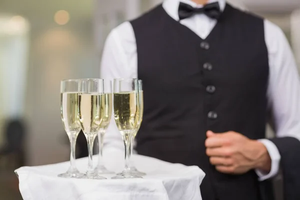 Waiter holding tray of champagne in a fancy restaurant — service, bow tie -  Stock Photo | #261781350