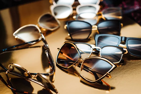 眼镜在一个现代时尚框架在一个金色的背景上的几个精英太阳镜 — 图库照片