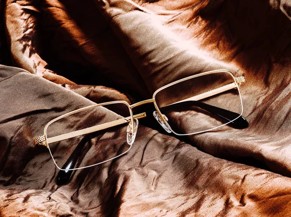 Sonnenbrille Auf Braun Glänzendem Stoff — Stockfoto