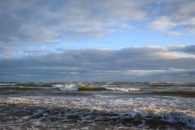 Bulutlu gökyüzüne karşı dalgalı deniz