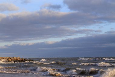 Bulutlu gökyüzüne karşı dalgalı deniz