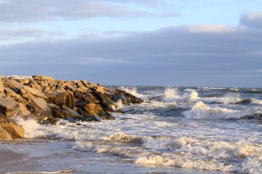 Bulutlu gökyüzüne karşı dalgalı deniz