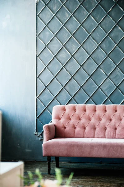 Pink sofa on blue wall background