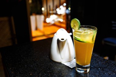 Turuncu kireç ve çaydanlık koyu arka plan üzerinde kokteyl