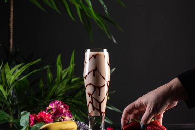 Muz ve çikolata koyu ahşap arka plan üzerinde uzun bir bardak muzlu süt