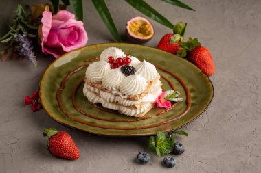 Kek krem şanti ve yeşil bir plaka üzerinde çilek