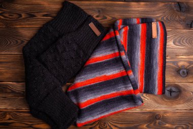 siyah ve kırmızı çizgili örme eşarp ve ahşap arka planda siyah örme kollu