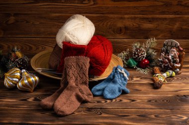ahşap arka planda iplik renkli topları, çok renkli örme çorap ve Noel ağacı süslemeleri
