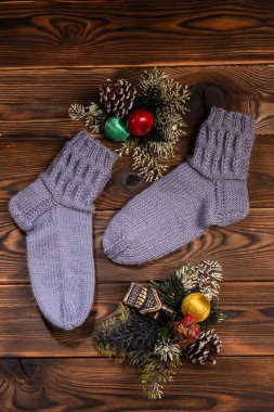 gri Örme Çorap, Noel süslemeleri ve ahşap bir arka planda Noel Baba görüntüsü ile metal bir kutu