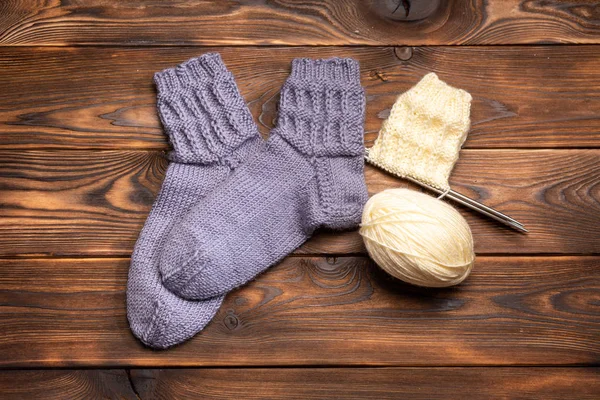 Šedé Pletené Ponožky Koule Bílého Závitu Pletací Jehlami Dřevěné Pozadí — Stock fotografie