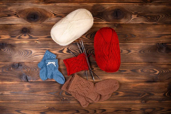 Farbige Fadenbälle Stricknadeln Und Gestrickte Socken Auf Einem Hölzernen Hintergrund — Stockfoto