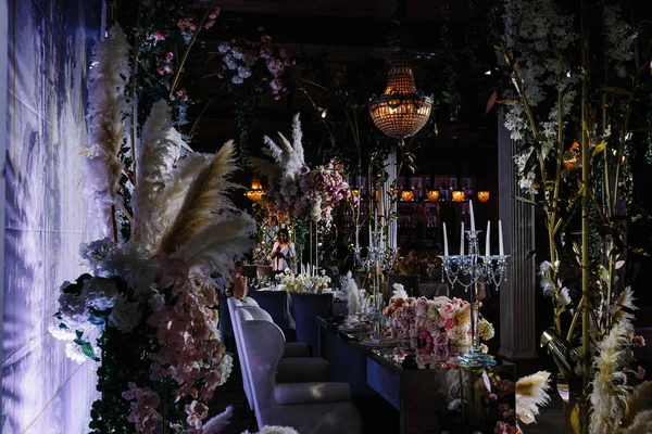 一个装饰着鲜花的婚礼大厅和挂在天花板上的别致的枝形吊灯 — 图库照片