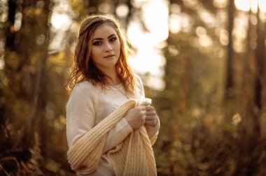 güneşli bir günde sonbahar orman bir arka plan üzerinde parlak giysiler içinde kızıl saçlı kız