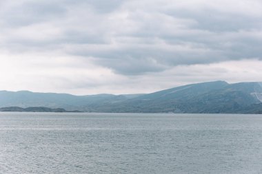 Kıyıdan Chirkei rezervuarına açılan manzara. Bulutlu gökyüzünün arka planında dağlar. Sulak Kanyonu, Dağıstan