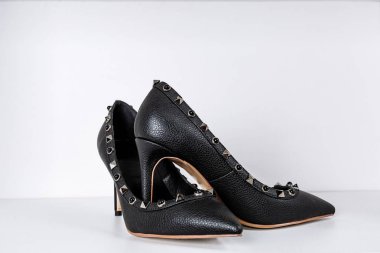 siyah yüksek topuklu ayakkabı çifti sivri ayak, mağazada bir rafa karşı metal ekler ile dekore