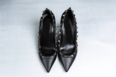 siyah yüksek topuklu ayakkabı çifti sivri ayak, mağazada bir rafa karşı metal ekler ile dekore