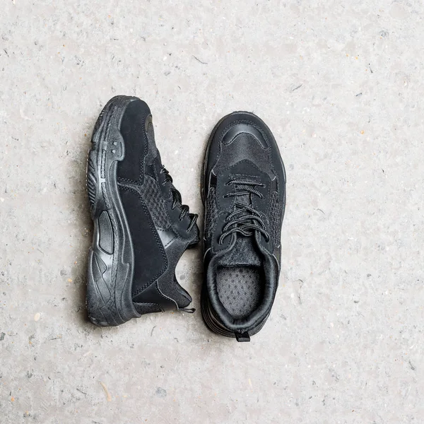 Чорні кросівки на товстій підошві на бетонному фоні — стокове фото
