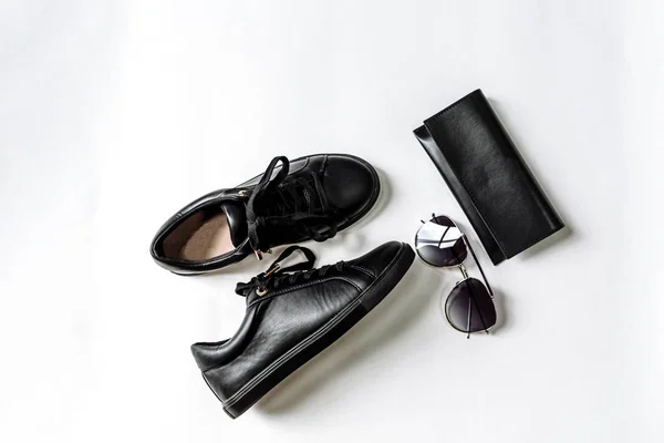 Sapatos pretos, bolsa e óculos de sol com lentes pretas em um fundo claro — Fotografia de Stock