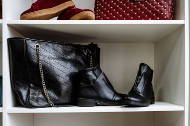 siyah deri ayakkabı rhinestones ve mağazada beyaz bir rafta bir zincir üzerinde siyah deri çanta ile dekore