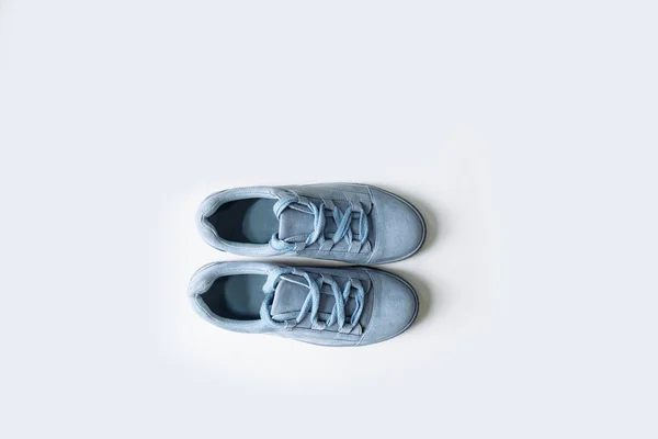 pair of blue suede shoes with thick laces on a white background
