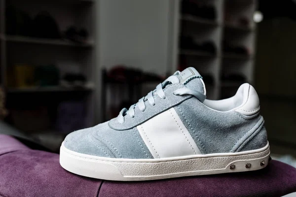 A pair of blue suede sneakers on a white sole with white accents on a background of shop — Stock Photo, Image