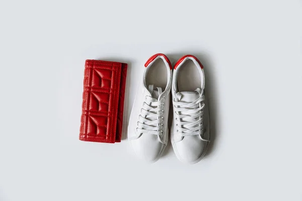 赤い背中と白い背景に赤い財布を持つ白い革のスニーカーのペア. — ストック写真