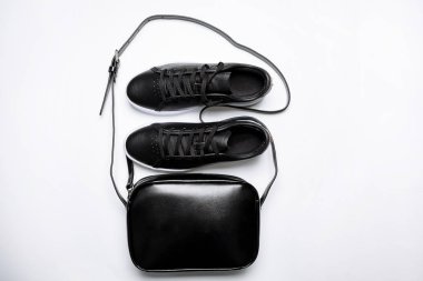 beyaz arka plan üzerinde beyaz taban ve siyah deri çanta ile siyah deri spor ayakkabı