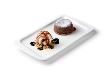 çikolata fondan ve izole beyaz bir arka plan üzerinde beyaz bir tabakta dondurma bir kepçe