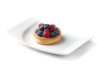 izole beyaz bir arka plan üzerinde beyaz bir tabak çilek ile tartlet