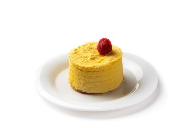 Beyaz arka planda izole edilmiş beyaz bir tabakta ahududu ile süslenmiş sarı pasta.