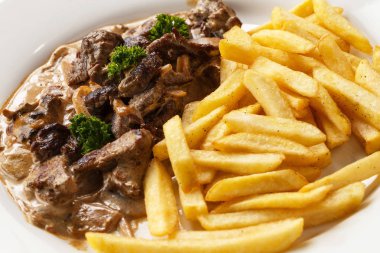 et gulaş ve kızarmış patates izole beyaz arka plan closeup bir tabakta