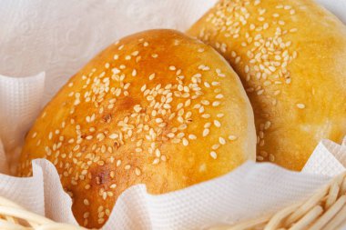 izole beyaz bir arka plan üzerinde bir sepet içinde susam çörekler