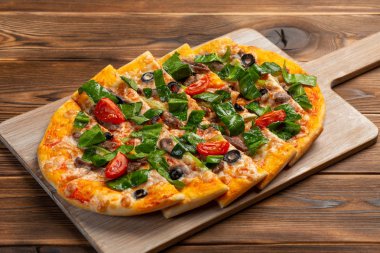 ahşap bir arka plan üzerinde dana eti ve kurutulmuş domates ile pizza