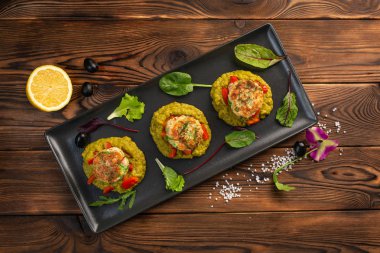 siyah bir tabakta yeşil bezelye püresi ile deniz pirzola