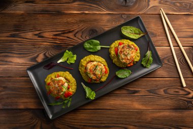 siyah bir tabakta yeşil bezelye püresi ile deniz pirzola