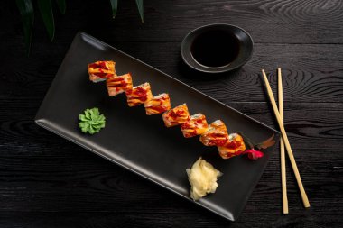 siyah dikdörtgen bir tabak üzerinde suşi rulo seti 