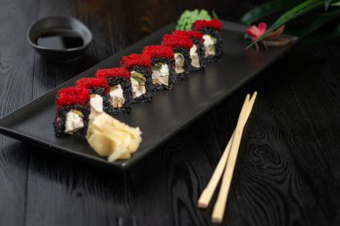 siyah dikdörtgen plaka üzerinde siyah suşi rulo seti 