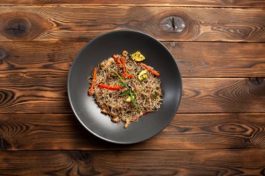 siyah bir tabakta deniz ürünleri erişte chow