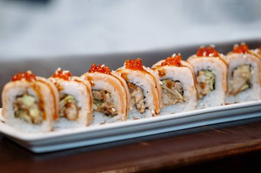 Suşi ahşap bir masa üzerinde dikdörtgen bir plaka üzerinde ayarlayın