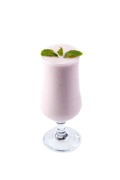 Batido de frutas e leite em um copo na perna decorado com folhas de hortelã em um fundo branco isolado — Fotografia de Stock