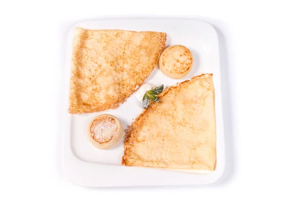 Izole beyaz bir arka plan üzerinde beyaz dikdörtgen bir tabakta ekşi krema ile krep ve börek — Stok fotoğraf