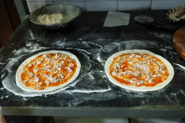 Dois círculos de massa em uma placa preta em um restaurante. cozinhar pizza — Fotografia de Stock