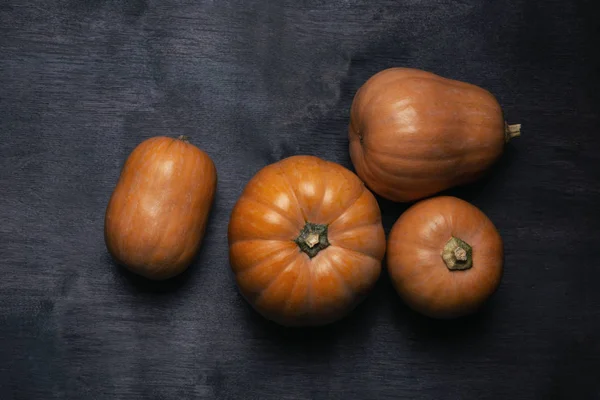 Pumpkins on dark wooden background view from above — Stock Photo, Image