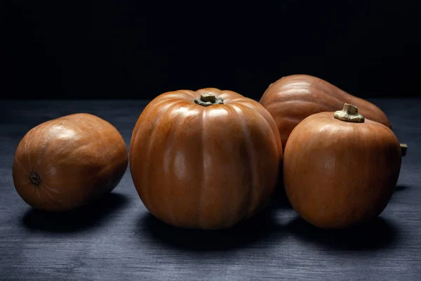 Pumpkins on dark wooden background side view — Stock Photo, Image
