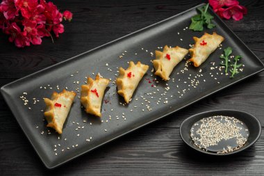 ebi gedza Çin usulü karides ve sebzeli kızarmış hamur köftesi, sos ile servis edilir.