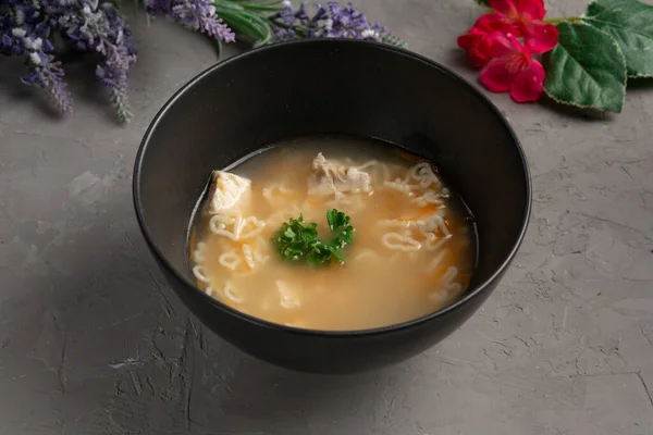 Sup mie ayam berbentuk hati dalam piring hitam — Stok Foto