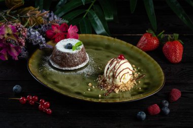 Çikolatalı turta ve yeşil tabakta bir kepçe dondurma.