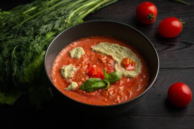 Siyah tabakta domates kremalı çorba.