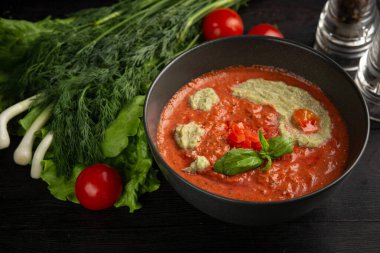 Siyah tabakta domates kremalı çorba.